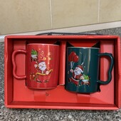 Набір із двох різдвяних керамічних кухлів у подарунковій коробці.